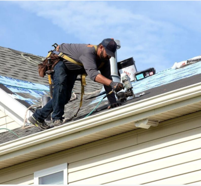 Roofing contractors finish off a roof by nailing in shingles.