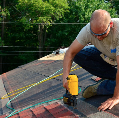 Roof builder uses a dewalt nail gun to install the shingles on a roof.